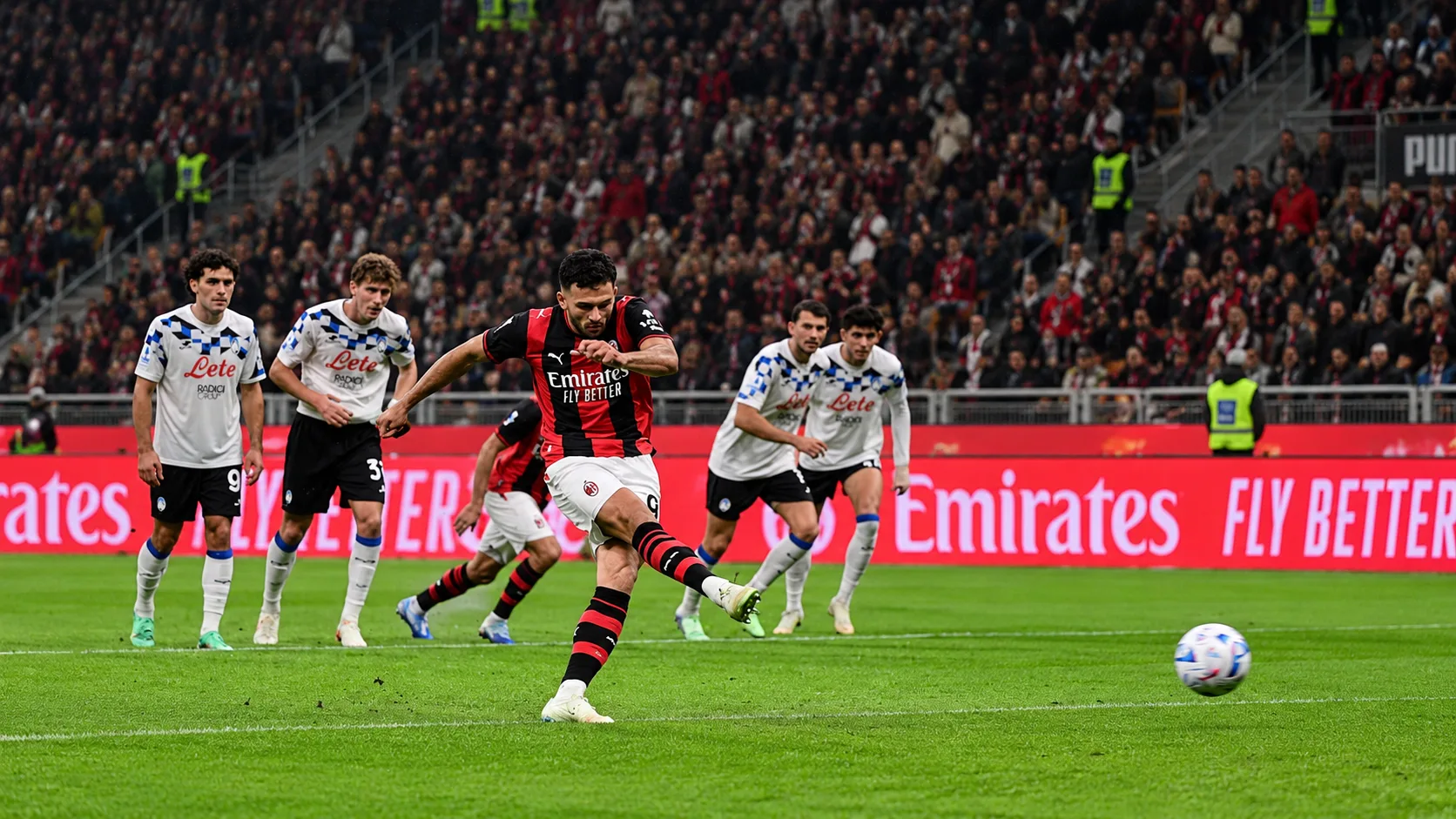 Ballon immobile près du rond central et joueurs de l’AC Milan et de l’Atalanta répartis sur la pelouse après le match.