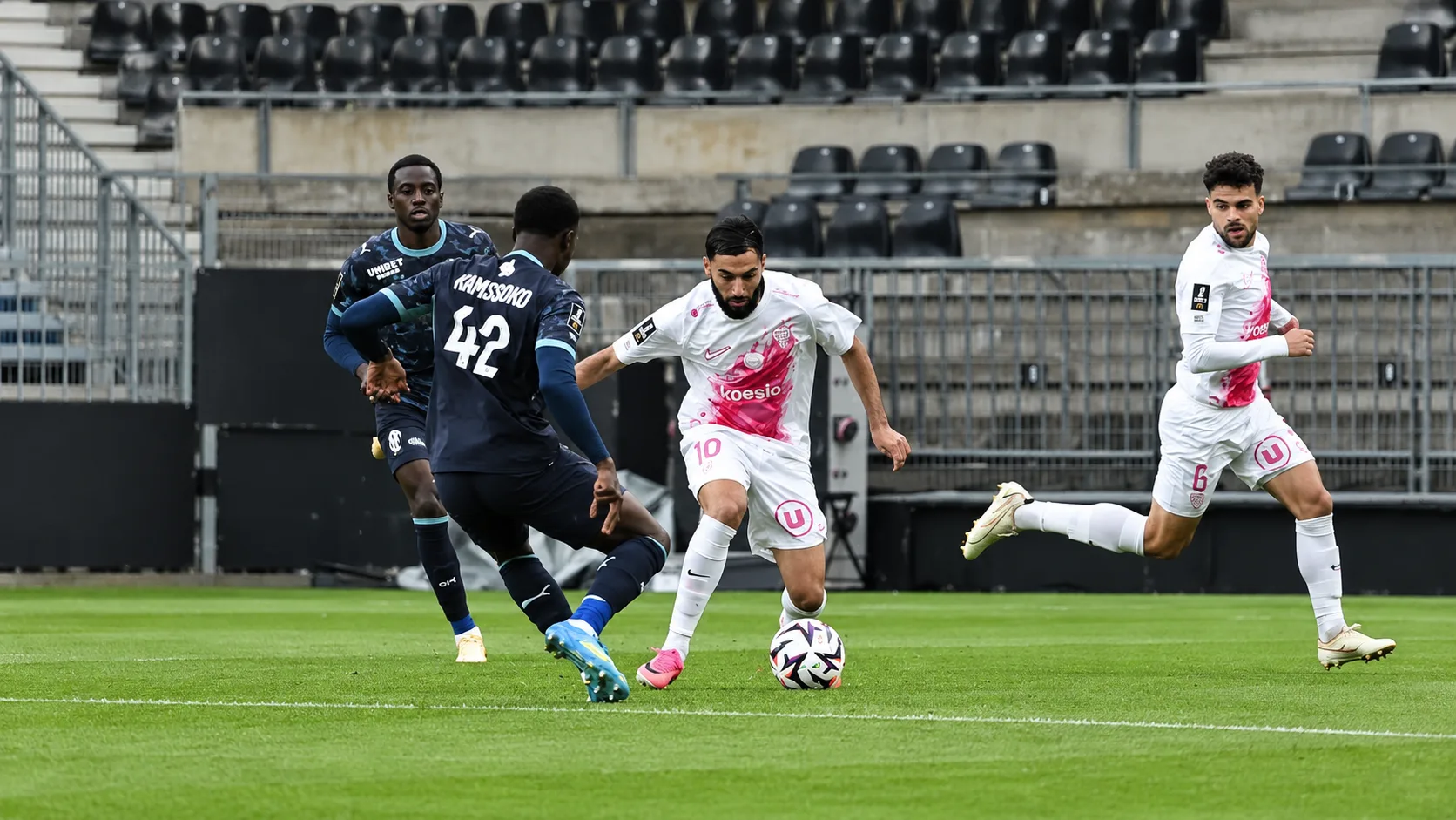 Ballon immobile près de la ligne médiane et joueurs d’Angers et de Marseille répartis sur la pelouse après le match.