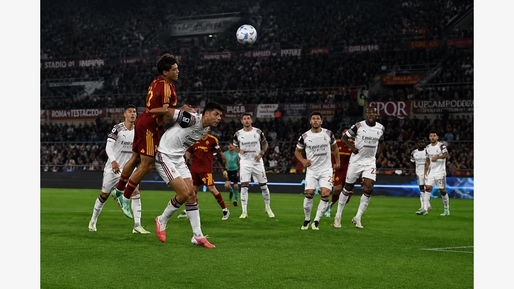 Emanuele Lulli de l&rsquo;AS Roma et M'Bala Nzola de Cagliari Calcio se disputent le ballon au premier plan devant des tribunes flout&eacute;es.