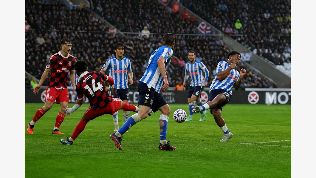 Oscar Bobb de Fulham et Jack Rudoni de Coventry se disputent le ballon au premier plan, devant des tribunes floutées.