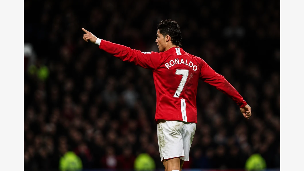 Cristiano Ronaldo conduit le ballon et observe une option de passe sur la pelouse, en tenue de Manchester United.