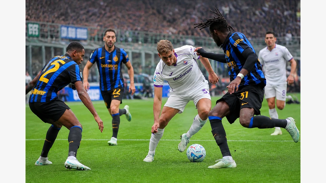 Marcus Thuram de l’Inter et Álex Jiménez de la Fiorentina se disputent un ballon près de leurs pieds devant des tribunes floutées.