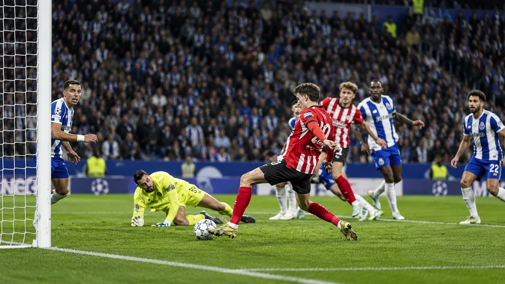 Ballon immobile près du rond central et joueurs du FC Porto et du PSV répartis sur la pelouse après le match.