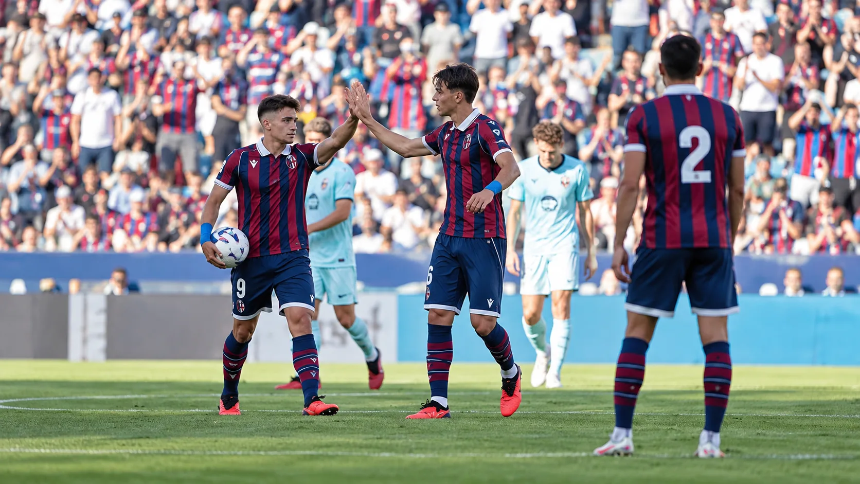 Joueurs anonymes des deux &eacute;quipes r&eacute;partis sur la pelouse dans une sc&egrave;ne neutre de fin de match.