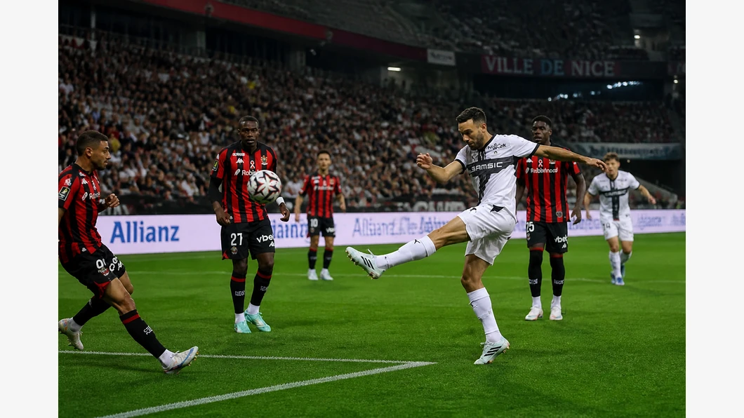 Jonathan Clauss de Nice et Boulaye Dia de Rennes se disputent le ballon au premier plan devant des tribunes floutées.