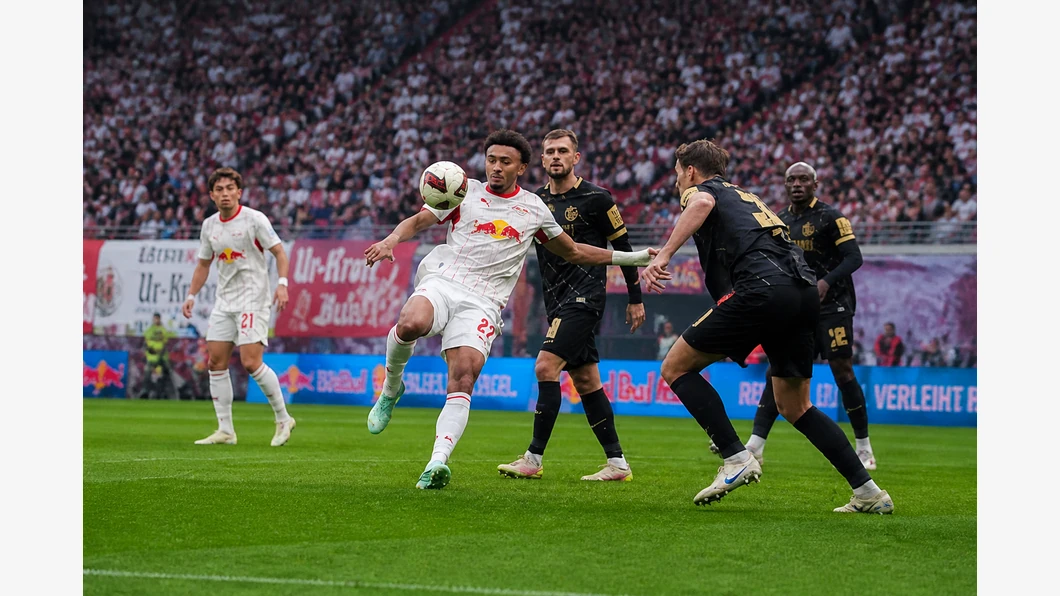 Tidiam Gomis du RB Leipzig et David Mokwa du SV Elversberg se disputent un ballon près de leurs pieds sur la pelouse.