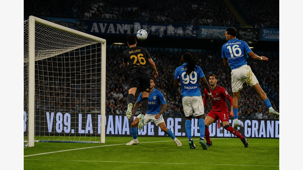 Scott McTominay du Napoli et Leonardo Balerdi de la Roma se disputent un ballon pr&egrave;s de leurs pieds, devant des tribunes flout&eacute;es.
