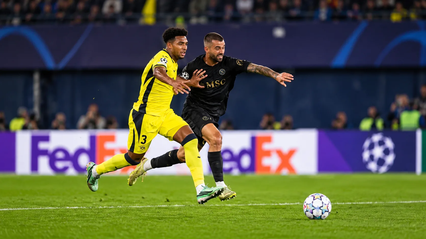 Ballon immobile pr&egrave;s de la ligne m&eacute;diane et joueurs en jaune et bleu r&eacute;partis sur la pelouse.